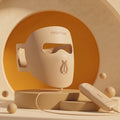 Hello Face M300 beige silicone LED mask with handheld controller in a warm studio setting